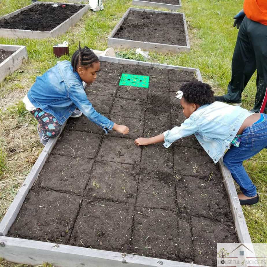 Children helping with planting a garden bed. 